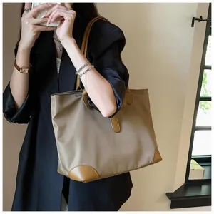 Detail shot of a stylish khaki tote bag with brown leather trim, large capacity for daily use.