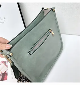 Green PU leather shoulder tote bag detail showing zipper pocket and leopard print strap.