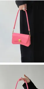 Detail view of the pink leather underarm baguette bag showing the elegant gold metal hardware lock.