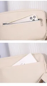 Detailed view of women PU leather crossbody bag, pebble grain texture, zipper pocket and strap.