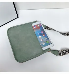 Green crossbody bag detail showing large capacity with stylish leopard print strap for women.