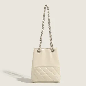 Beige quilted bucket bag featuring a chic chain strap, elegant shoulder handbag for women.