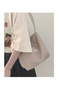 Beige canvas shoulder bag detail view, casual minimalist underarm bag with sturdy white straps.
