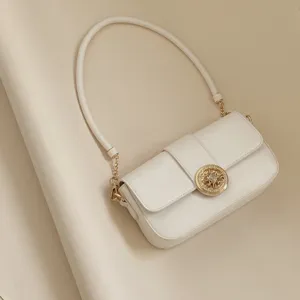 Elegant white leatherette baguette shoulder bag with chic gold hardware and chain strap details.