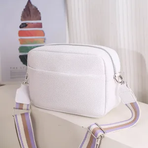 White PU leather crossbody bag for women with wide striped strap and zipper closure.