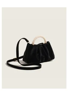 Dettaglio borsa a nuvola plissé nera che evidenzia l'elegante manico in perle e la tracolla chic.