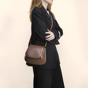 Close-up details of the vintage brown PU leather saddle bag showing texture and stylish wear.