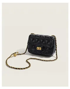 Black quilted leather chain bag detail showing golden turn lock and metal ball strap adjuster.