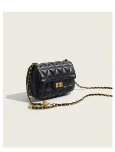 Close-up of black quilted leather crossbody bag with vintage gold chain and metal ball detail.