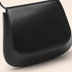 Close-up detail of black PU leather saddle bag, showing smooth texture and fine stitching.