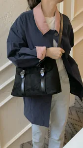 Vintage black suede messenger bag for women, retro crossbody satchel with double buckle.
