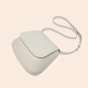 Minimalist PU leather crossbody saddle bag for women, elegant light grey chic shoulder bag.