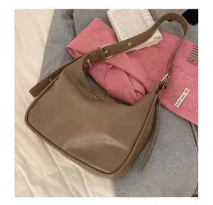 Detailed view of brown slouchy leather shoulder bag displayed with stylish lifestyle props.