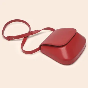 Close-up detail of the smooth red PU leather chestnut bag showing fine texture and stitching.