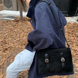 Vintage black suede messenger bag for women, retro style crossbody satchel with double buckles.
