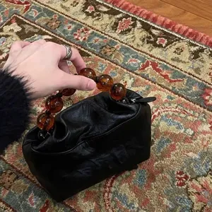 Vintage black puffy handbag with amber beaded handle, elegant Chinese style chic clutch bag.