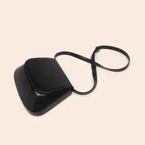 Detail view of minimalist black PU chestnut shoulder bag, elegant retro design, classic saddle shape.