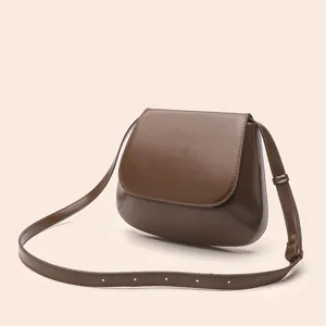 Close-up detail of the vintage brown PU leather saddle bag showing smooth texture and strap.