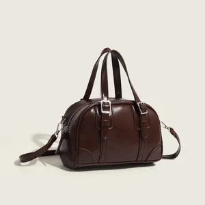 Dark brown retro pillow bag for women, chic top handle shoulder crossbody bag with buckle decor.