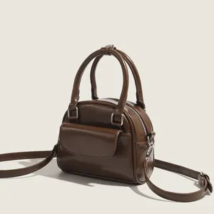 Glossy brown mini crossbody handbag for women, retro shell bag with top handles and strap.