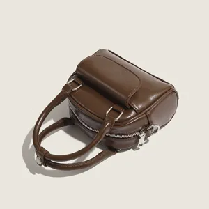 Stylish brown leather mini handbag with top handles and front pocket for women daily use.
