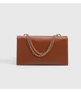 Brown leather crossbody bag detail, chic chain strap and minimalist design for women.
