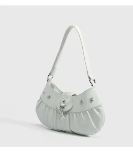 Close-up detail of mint green shoulder bag, pleated bottom and silver star charms.