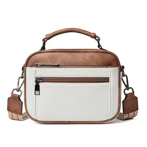 Women's color-block crossbody square bag with top handle and adjustable patterned strap.