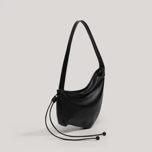 Vista detallada del bolso de hombro hobo de media luna de cuero negro, diseño único con cordón.