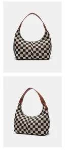 Sac à épaule rétro à carreaux noir et blanc avec lanière en cuir marron pour femmes.