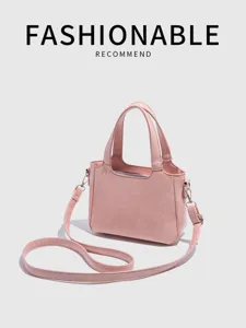 Pink leather handbag detail showcasing fine stitching, sturdy top handles and metal hardware.