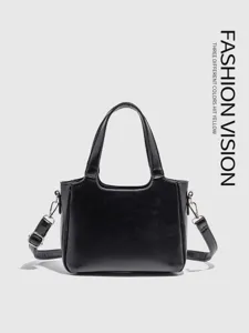 Black leather handbag detail showcasing fine stitching, sturdy handles and metallic hardware.