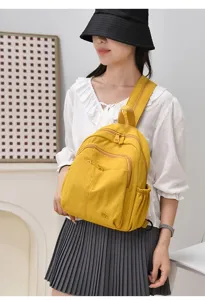 Detail view of the yellow nylon backpack featuring multi-compartment design, lightweight and practical.