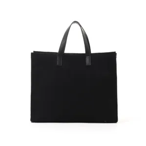 Black suede tote bag detail, featuring durable leather handles and spacious interior design.