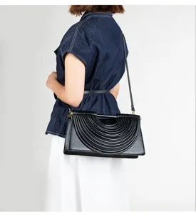 Detail view of French vintage pleated noodle handbag with unique curved design and strap.