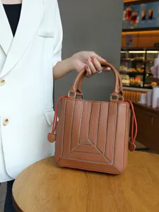 Stylish brown leather tote bag for women, chic geometric design with shoulder strap and top handle.