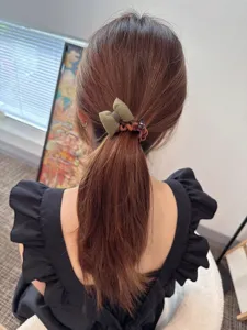 Vista dettagliata del grazioso elastico per capelli a treccia con fiocco imbottito.