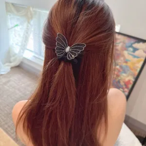 Detailed view of the elegant mesh butterfly rhinestone hair scrunchie styling on long hair naturally.