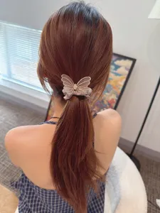 Detailed shot of sparkling rhinestone mesh butterfly hair scrunchie, elegant ponytail accessory.
