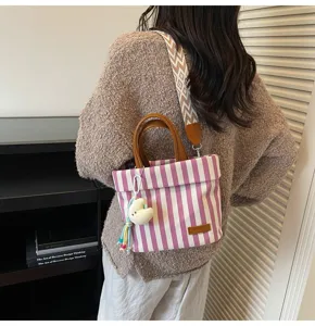 Striped canvas crossbody bag with top handles and wide strap for daily casual commuting style.