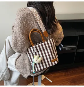 Stylish striped canvas tote bag with top handle and wide shoulder strap for women commute.