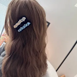 Vue détaillée de pinces à cheveux en velours strass brillant, design élégant pour coiffure.