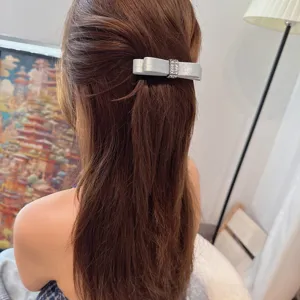 Elegante silberne Satin Schleife Haarklammer mit Strass Mitte für modisches Haarstyling.