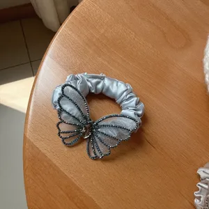 Detailed close-up of a silver mesh butterfly rhinestone hair scrunchie, elegant hair accessory.