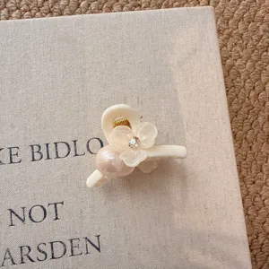 Nahaufnahme einer koreanischen weißen Blumen Perlen Haarklammer, filigranes Haaraccessoire.
