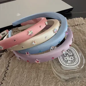 Detailed shot of pastel satin padded headbands embellished with sparkly crystal stars and rhinestones.