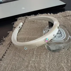 Detail shot of white satin rhinestone star headband, elegant hair accessory for women.