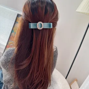 Close-up of retro blue velvet hair barrette featuring a sparkling rhinestone oval center detail.