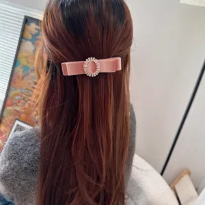 Pink velvet bow hair clip with sparkling rhinestone oval detail, elegant hair accessory for women.