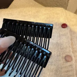 Gros plan de peignes à cheveux noirs en plastique, outil de coiffure pour frange et têtes.